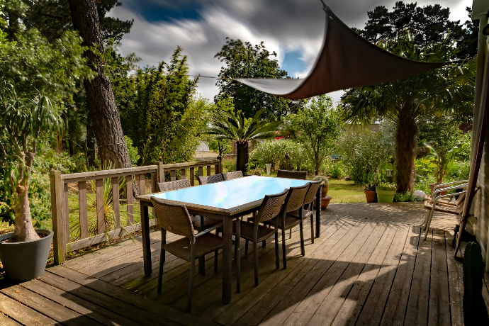 brown wooden table with chairs and umbrella